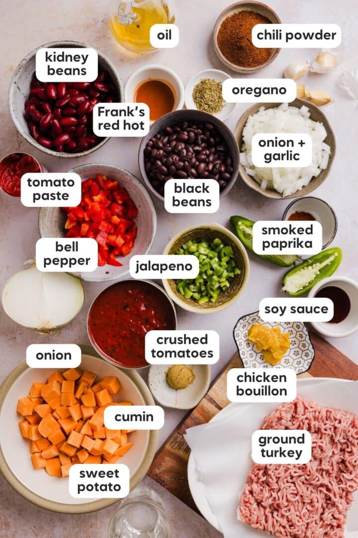Labeled photo of ingredients for sweet potato turkey chili, displayed in small bowls on a kitchen counter.