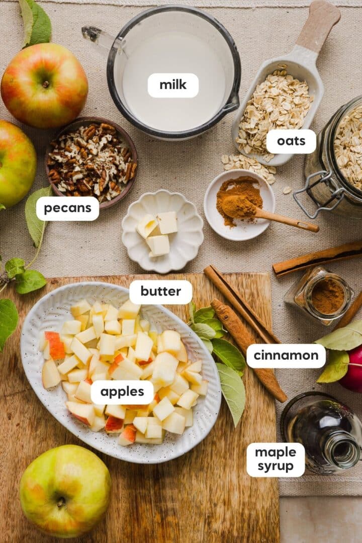 Ingredients for apple cinnamon oatmeal displayed in small bowls on a kitchen counter.