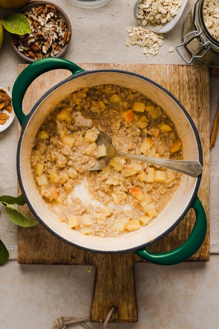 Cooked apple cinnamon oatmeal in a small pot.