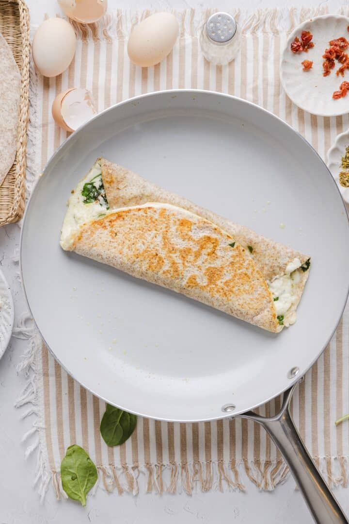 Folded Starbucks spinach egg white wrap in a large ceramic pan.