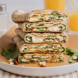Copycat Starbucks spinach feta wraps sliced in half and piled on a white plate.