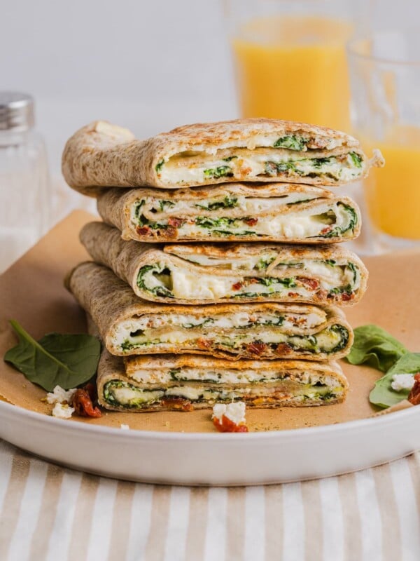 Copycat Starbucks spinach feta wraps sliced in half and piled on a white plate.