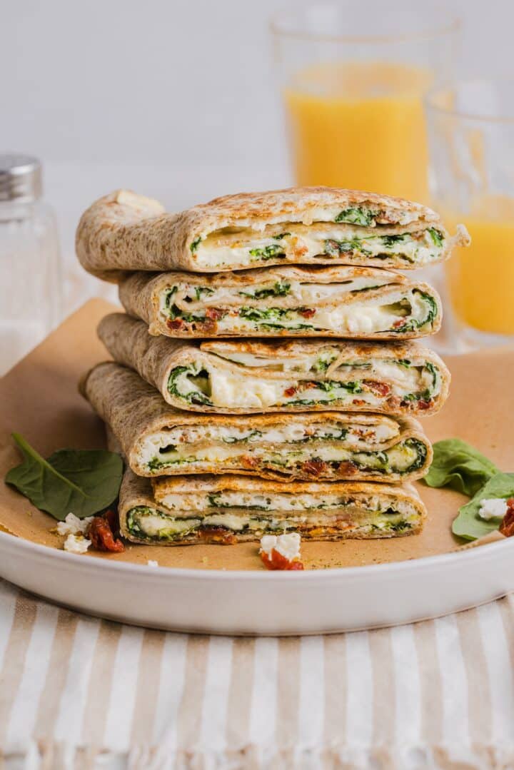 Copycat Starbucks spinach feta wraps sliced in half and piled on a white plate.
