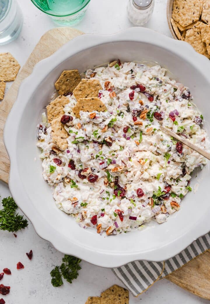 cranberry chicken salad in a large serving bowl with seeded crackers.