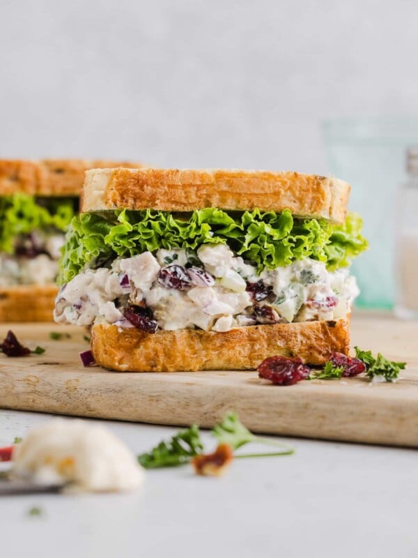 Cranberry pecan chicken salad inside a sandwich with lettuce.