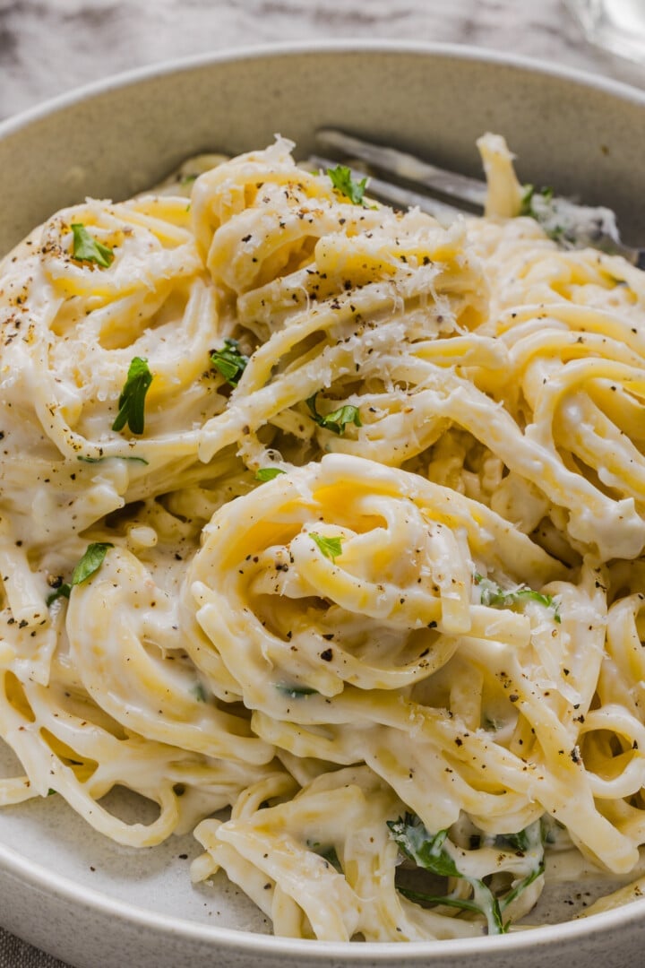Spaghetti with creamy cottage cheese alfredo sauce, topped with black pepper and chopped parsley.