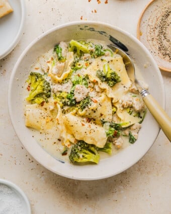 Creamy white lasagna soup in a white soup bowl with a spoon.