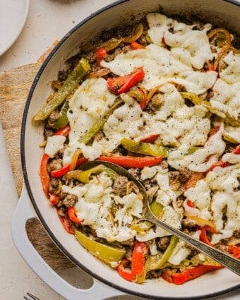 Philly cheesesteak skillet dinner with a serving spoon.