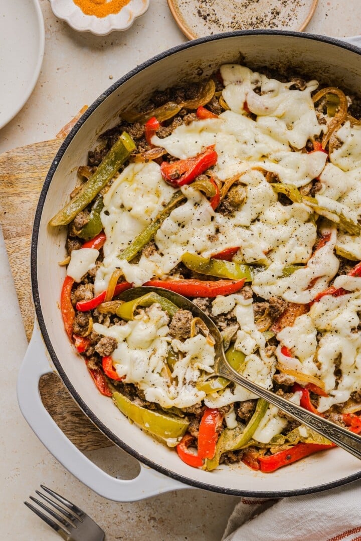 Philly cheesesteak skillet dinner with a serving spoon.