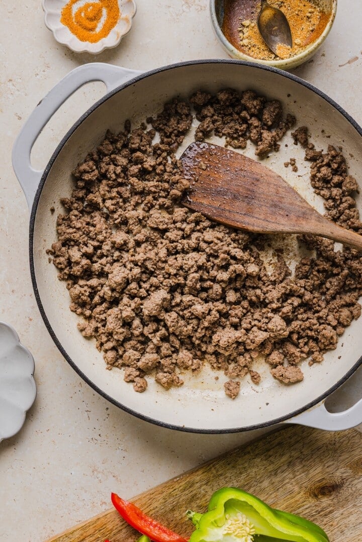 Crumbled ground beef in a large white pan.