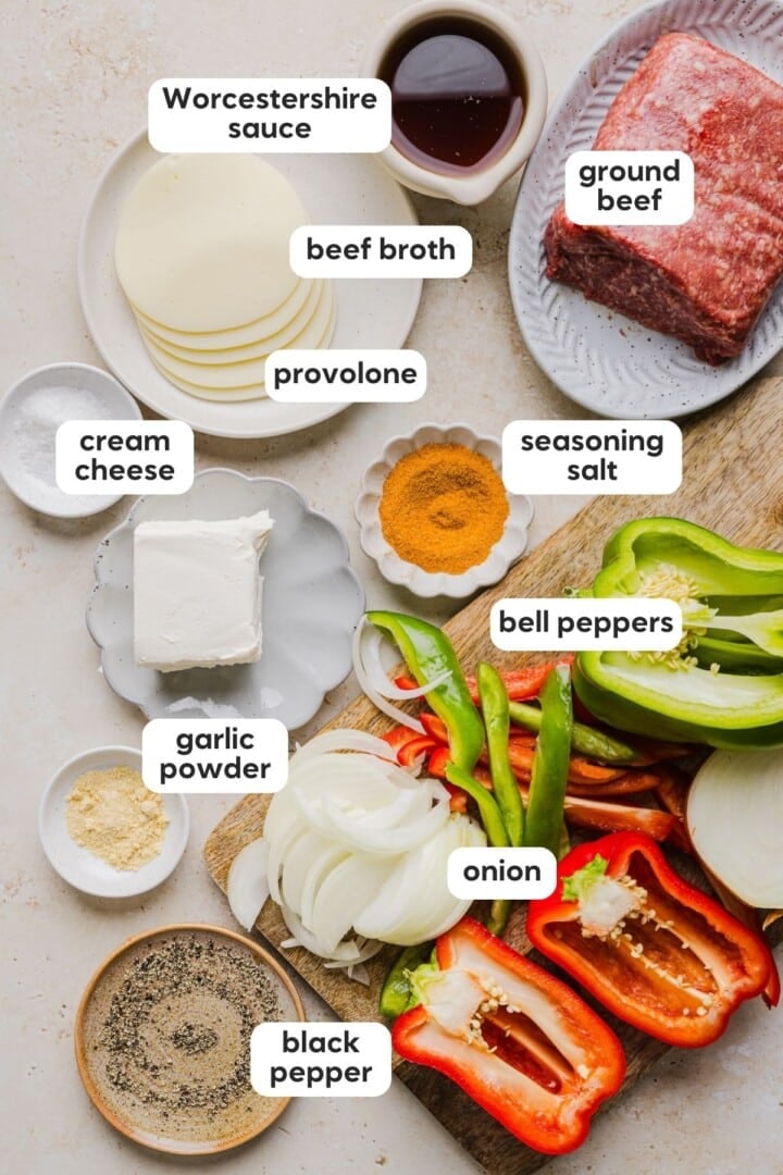 Ingredients for philly cheesesteak skillet dinner displayed in small bowls on a marble counter.