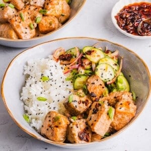 Bang bang salmon bowls with rice and cucumber salad.