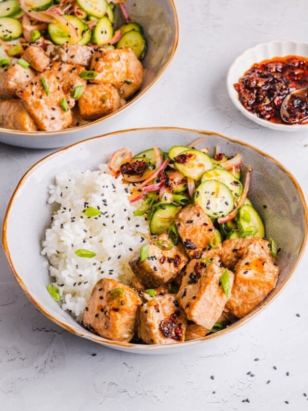Bang bang salmon bowls with rice and cucumber salad.