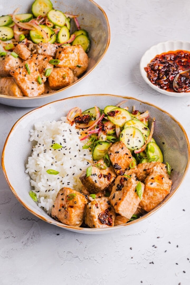 Bang bang salmon bowls with rice and cucumber salad.