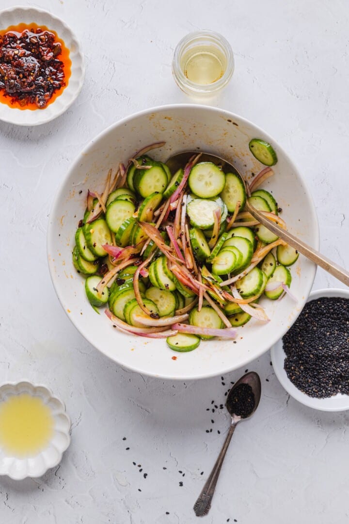 Cucumber salad in a large white bowl.