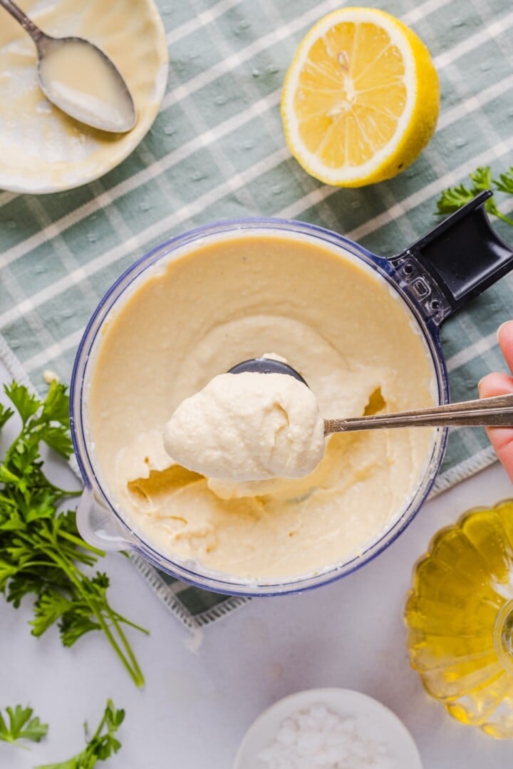 High protein hummus on a spoon over the food processor.