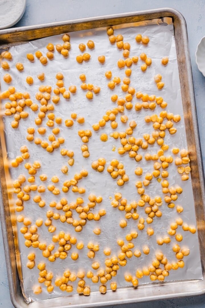 Chickpeas on aluminum, lined baking pan.