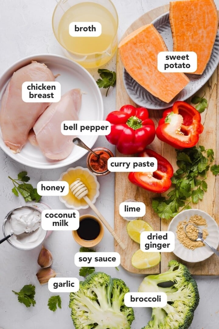 Ingredients for slow cooker red curry in small bowls on a grey marble counter.