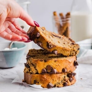 Three slices of cottage cheese banana bread with a woman's hand grabbing the top one.