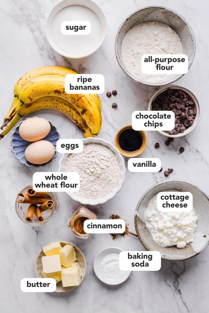 Ingredients for cottage cheese banana bread in small bowls on a marble counter.