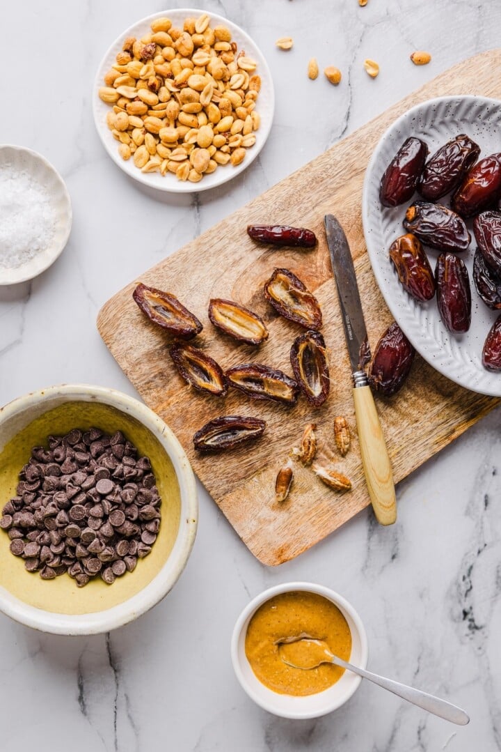 Open medjool dates on a wooden cutting board.
