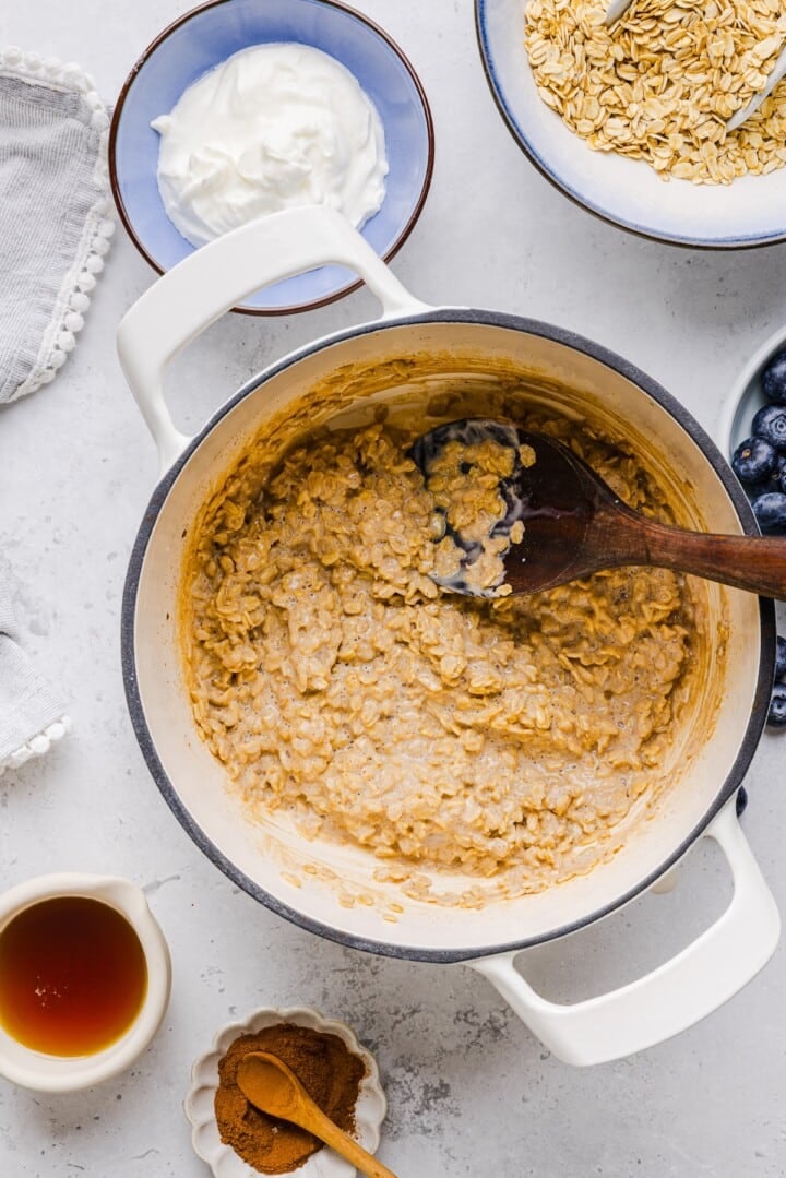 Thick Greek yogurt oatmeal in a white pot.