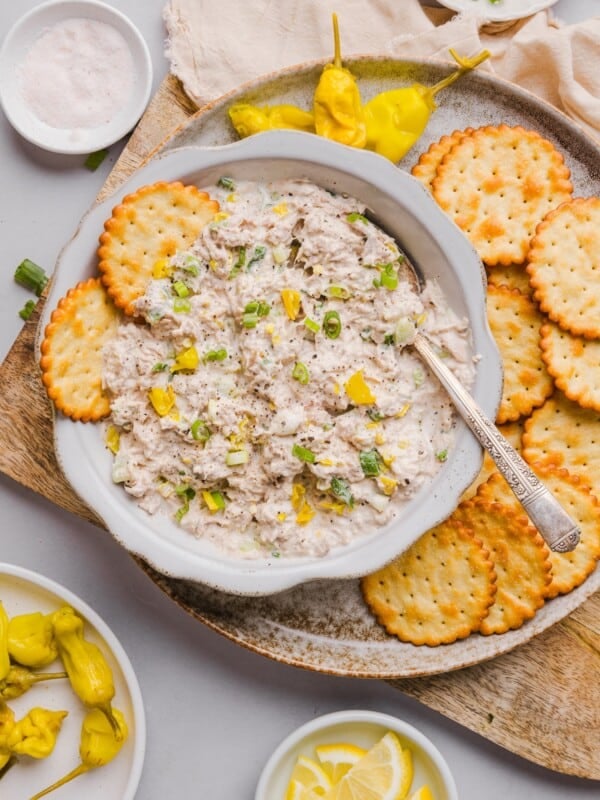 Pepperoncini tuna salad topped with sliced green onion in a white bowl, served with crackers.