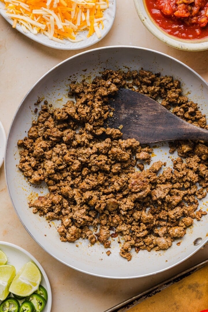 Ground beef browned and crumbled in a pan.