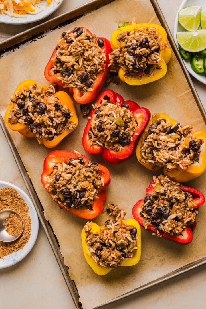Taco stuffed peppers uncooked on a sheet pan.