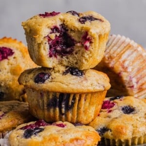 Protein pancake muffins with berries stacked on a muffin pan.