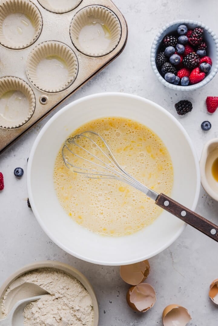 Wet ingredients for protein pancake muffins with kodiak mix in a large mixing bowl.