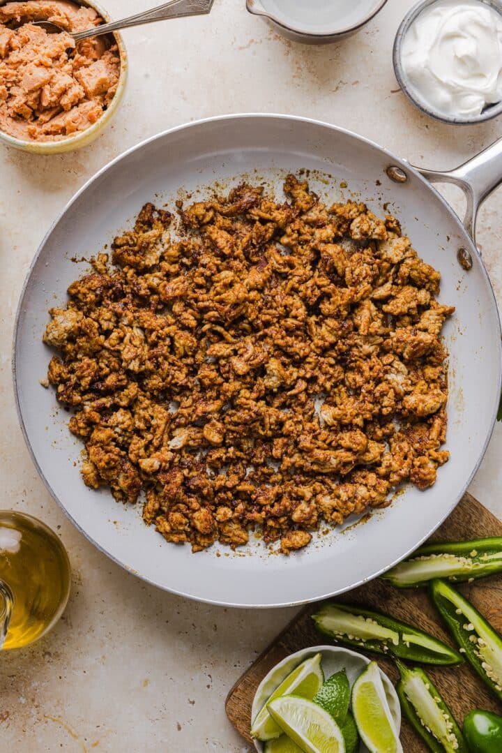 Ground turkey browning in a skillet with seasoning.