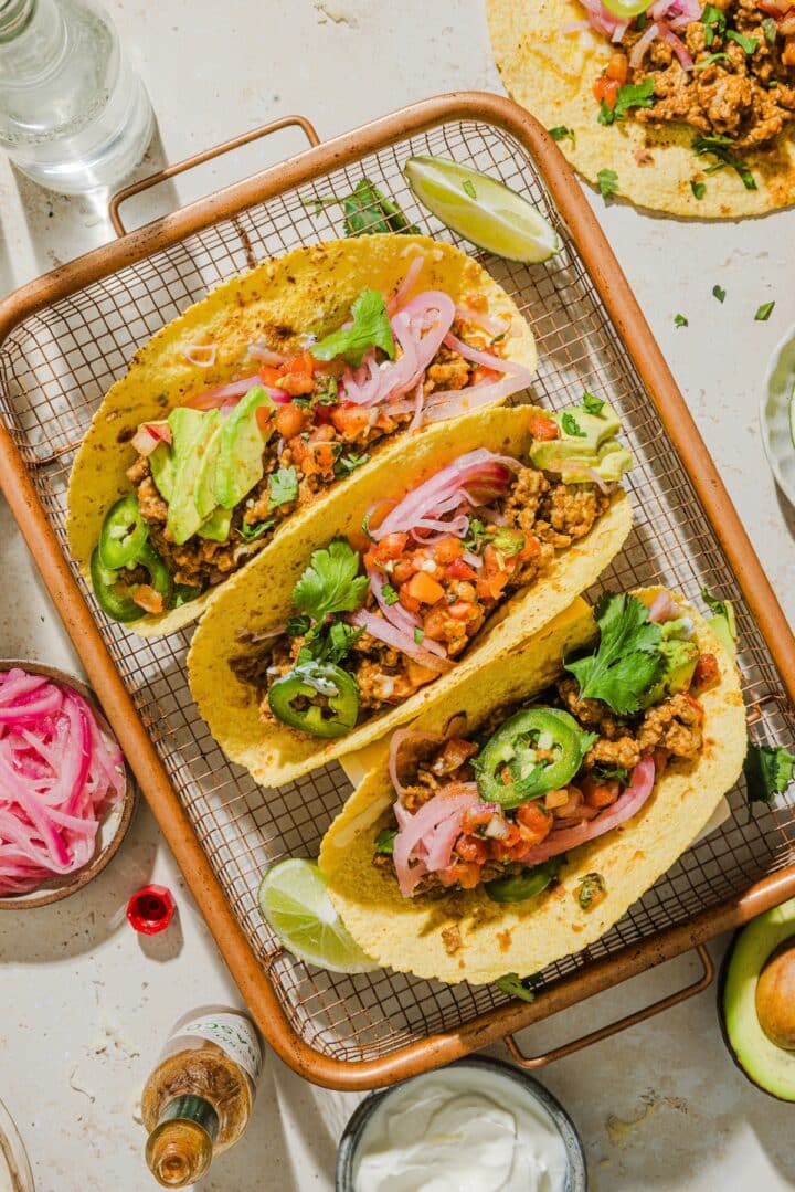 Filling tortillas with turkey taco meat and toppings.