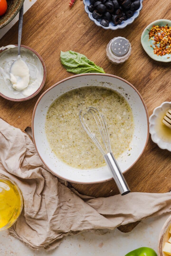 Italian vinaigrette in a small bowl with a whisk.