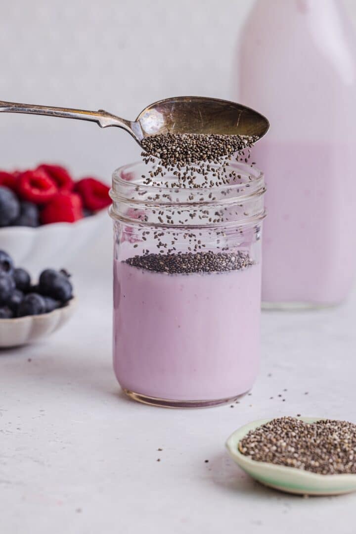 Chia pudding being poured into a jar with kefir.