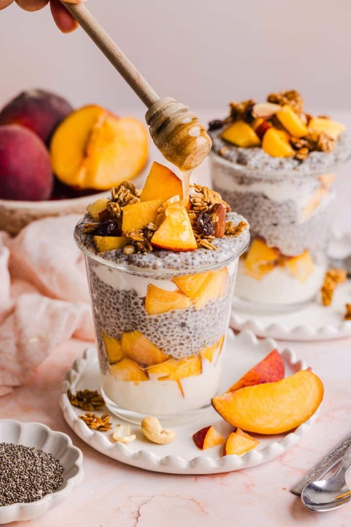 Honey being drizzled onto the peaches and cream chia pudding.