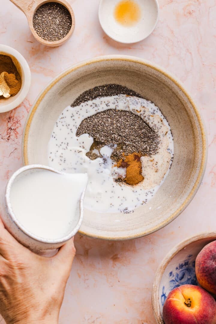 Milk being poured into a bowl with chia seeds.