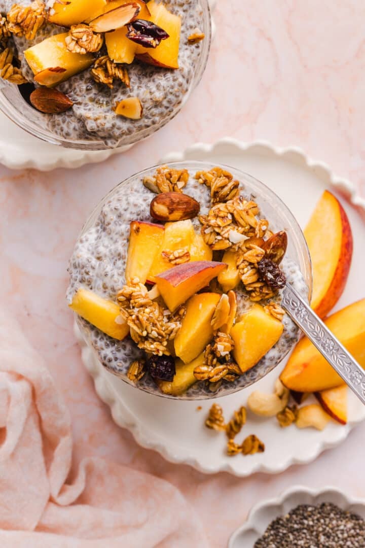 Toppings of diced peaches and granola added to the chia pudding