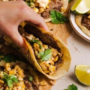 Lifting up a street corn taco.