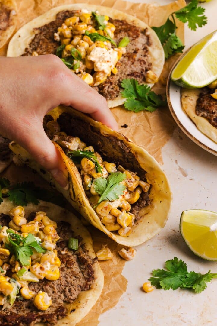 Lifting up a street corn taco.