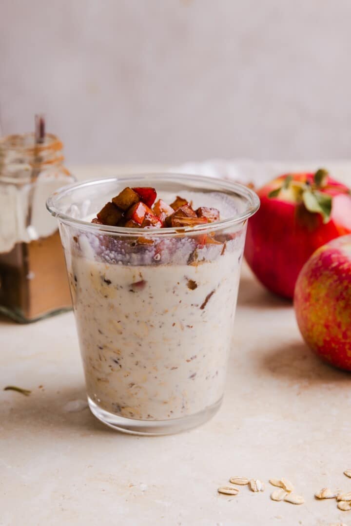 Glass jar with overnight oats and apple pie topping.