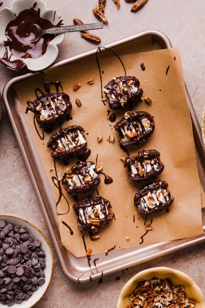 Cream cheese stuffed dates on parchment paper.