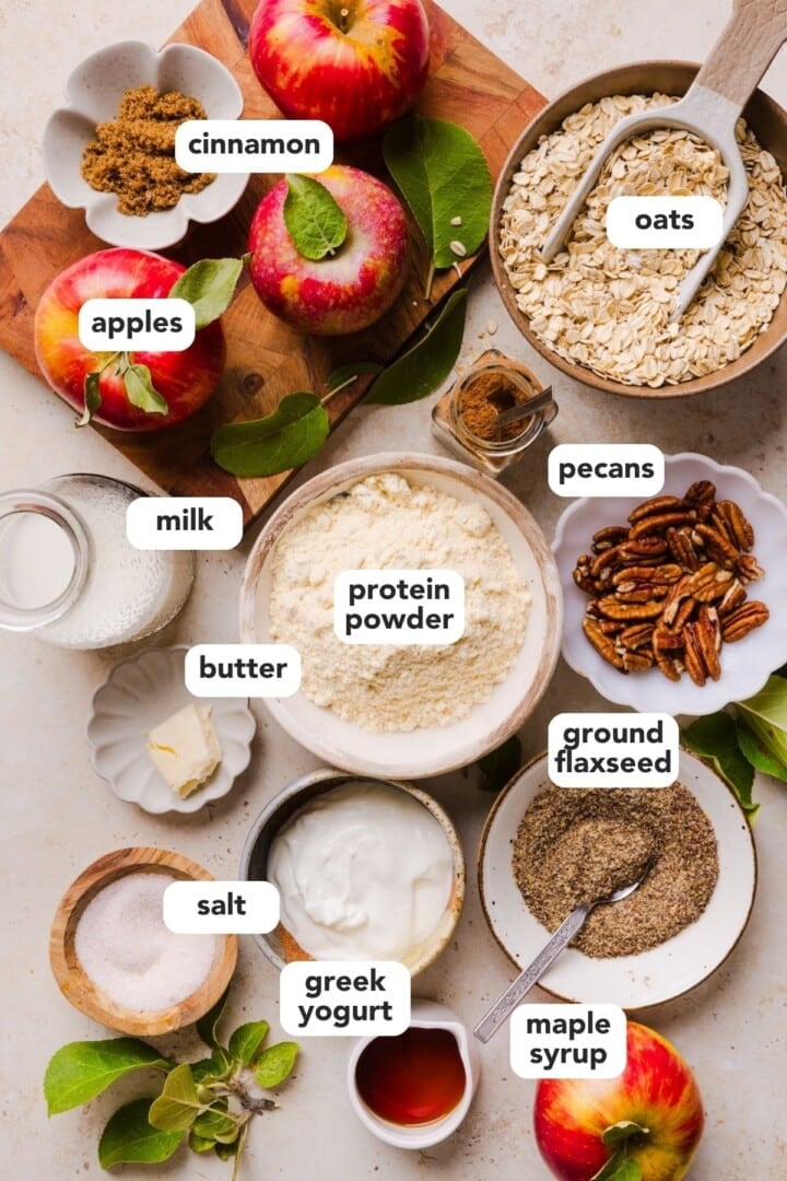 Ingredients for overnight oats displayed in small bowls on a marble counter.