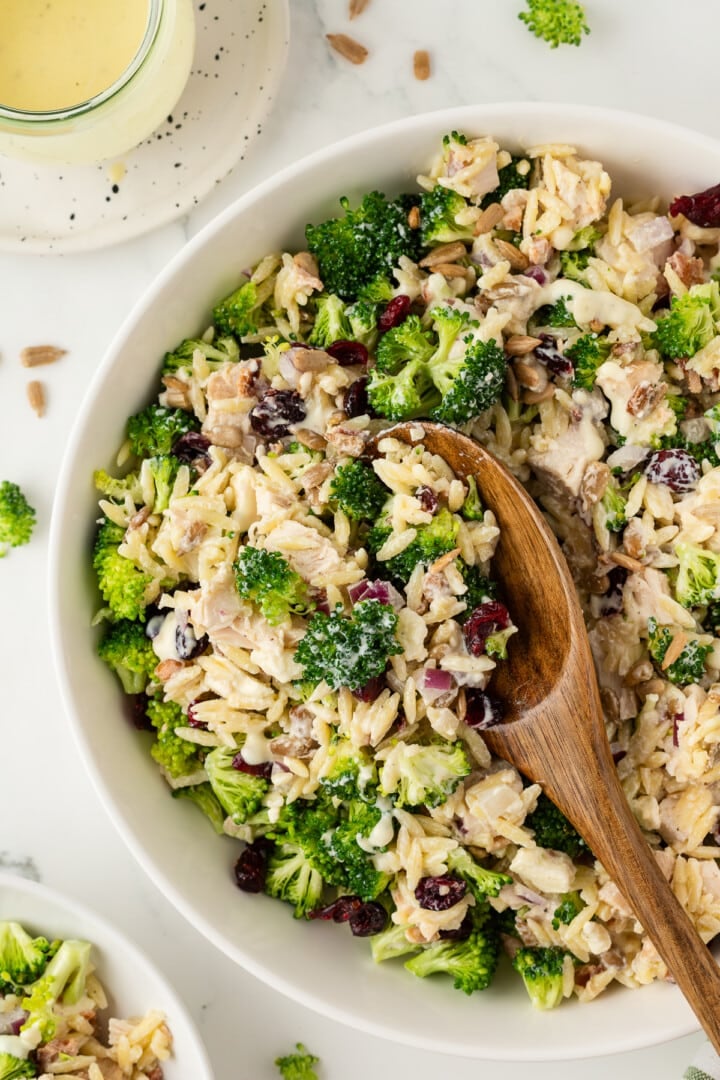 Broccoli pasta salad with orzo mixed in a white mixing bowl.