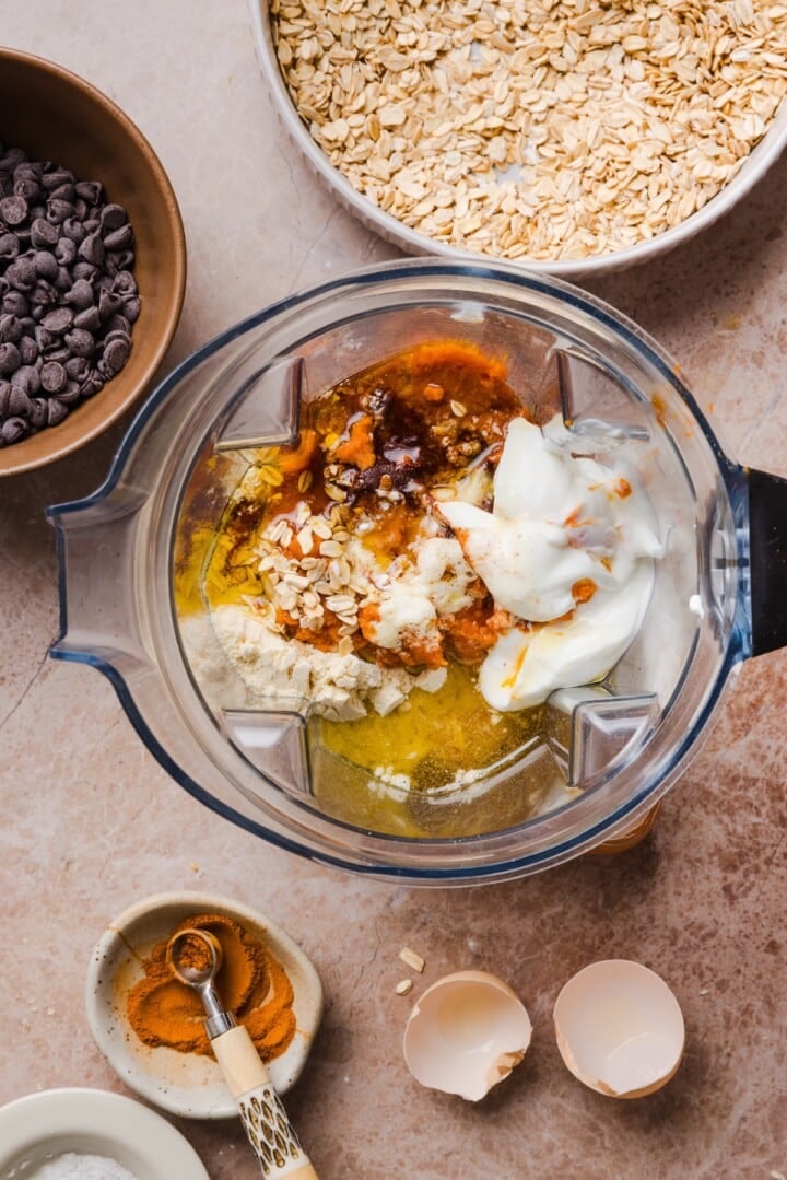 Ingredients for pumpkin protein muffin batter in a blender.