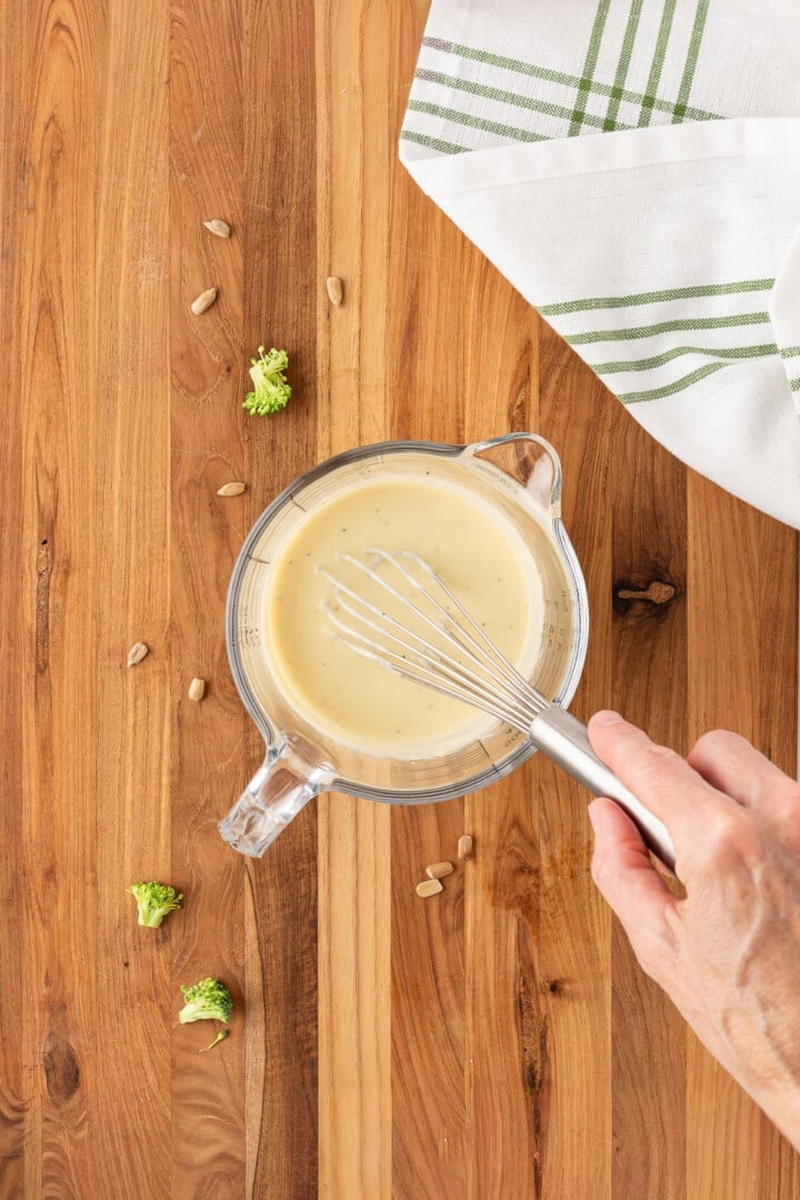 Creamy honey mustard dressing whisked in a glass mixing bowl.