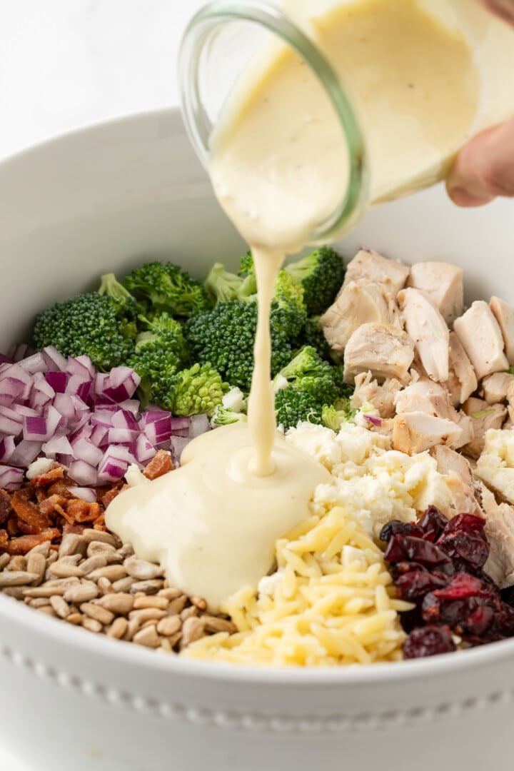 Creamy honey mustard dressing poured over broccoli pasta salad.