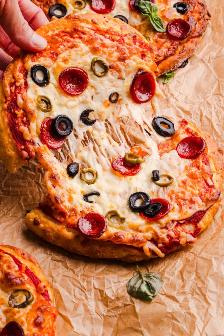 Cottage cheese pizza bun being pulled in half with a cheese pull.