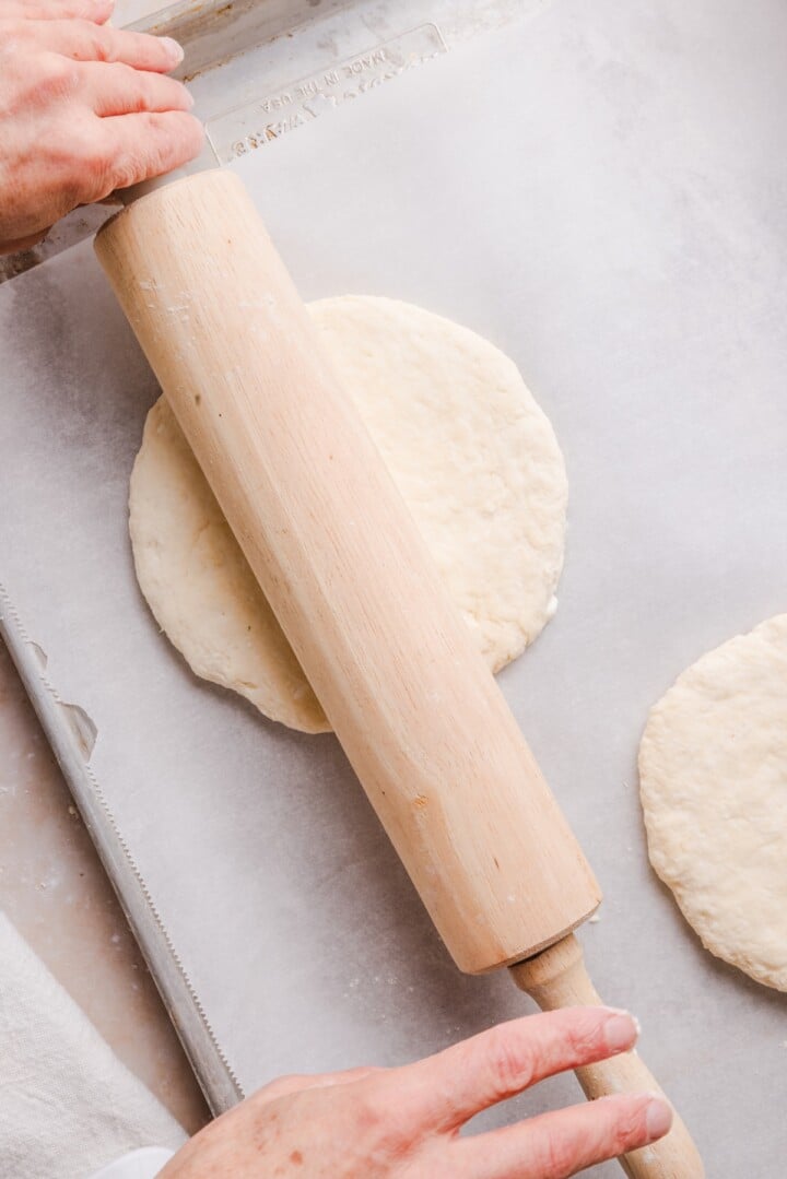 Rolling pin over cottage cheese pizza dough.