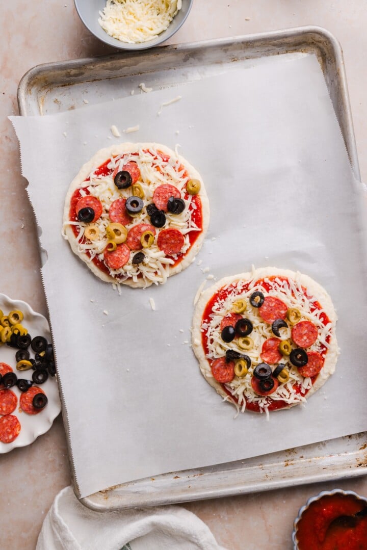 Raw cottage cheese pizza buns on a baking pan.
